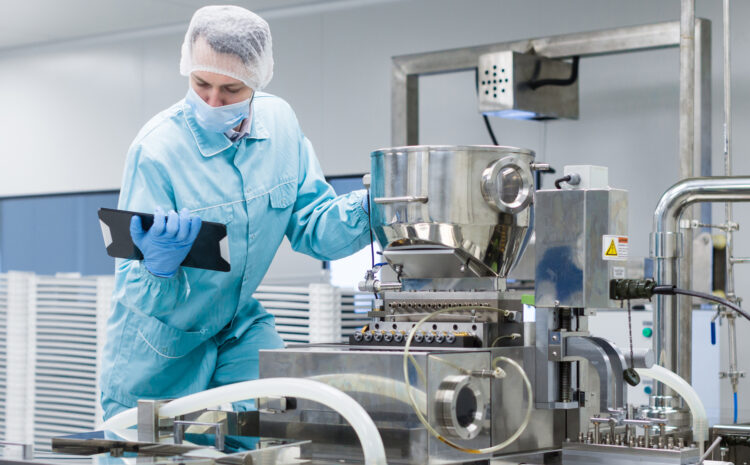 Funcionária da área de alimentos com um tablet na mão, conferindo os parâmetros dos equipamentos grandes
