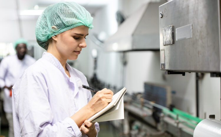 Profissional de qualidade registrando não conformidade em sistema digital na indústria de alimentos